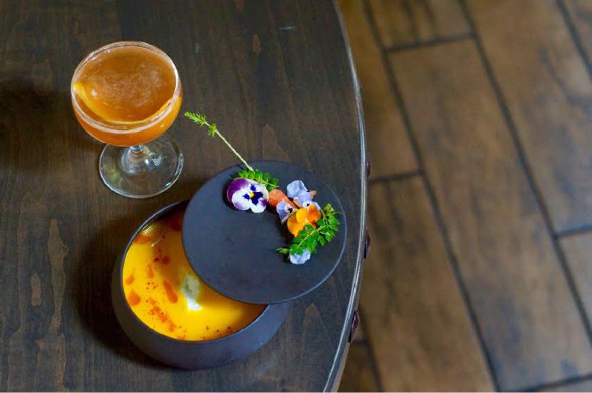 Veloute in a black bowl, with a cocktail